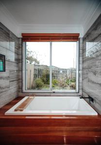 a large bath tub in a bathroom with a window at Craypot Cottage in Port Campbell