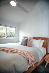a bedroom with a large bed with a window at Craypot Cottage in Port Campbell