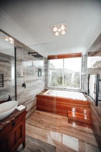 La salle de bains est pourvue d'une baignoire, d'un lavabo et d'une douche. dans l'établissement Craypot Cottage, à Port Campbell