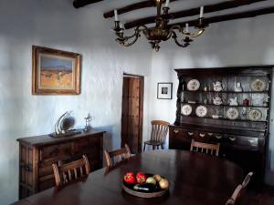 a dining room with a table and a chandelier at Beautiful Cortijo with pool near Ronda in Ronda
