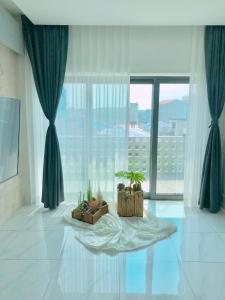 a room with two potted plants and a large window at Preun Jeju Pension in Seogwipo