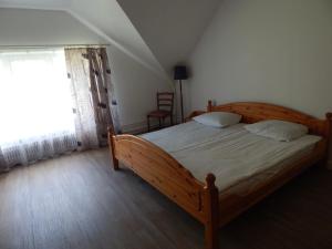 a bedroom with a wooden bed and a window at Motel Brencis in Iecava