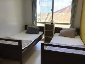2 Betten in einem Zimmer mit Fenster in der Unterkunft Shimaotoya in Iriomote
