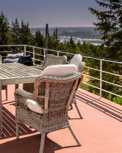 a wicker table and chairs on a deck with a view at Made iN2 Creative Guest House in Montargil