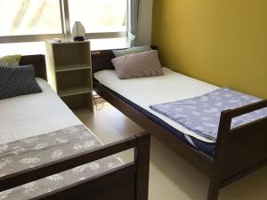 a room with two bunk beds and a window at Shimaotoya in Iriomote
