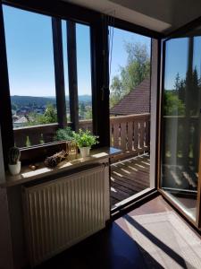 a balcony with large windows and a view of the yard at Pension Reithmeier in Nagel