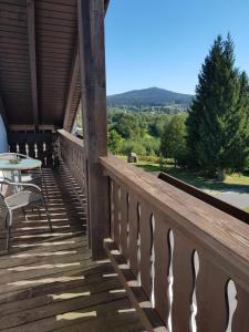 a wooden deck with a table and chairs on it at Pension Reithmeier in Nagel