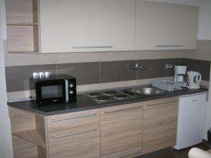 a small kitchen with a microwave and a sink at Apartments Sven in Rastovača