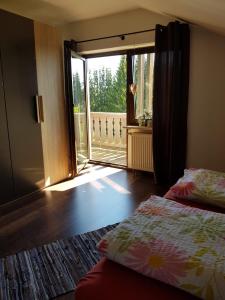 a room with two beds and a sliding glass door at Pension Reithmeier in Nagel