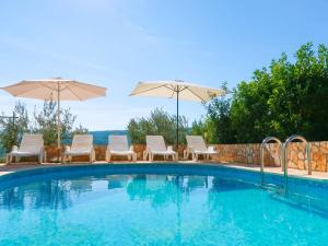 a swimming pool with chairs and umbrellas at Apartment Chantal-3 by Interhome in Rabac +21 photos