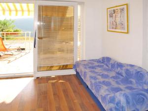 a living room with a couch in front of a sliding glass door at Apartment Chantal-3 by Interhome in Rabac