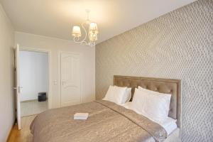 a bedroom with a bed and a chandelier at Liepų Apartments in Druskininkai