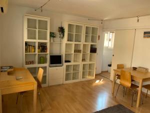 a living room with a dining table and a tv at REGINA - A cosy air conditioned studio just minutes from Rialto in Venice