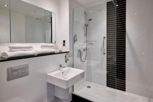 a bathroom with a sink, toilet and bathtub at Holiday Inn Corby Kettering A43, an IHG Hotel in Corby