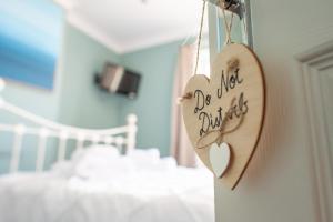 a wooden heart hanging on a wall in a bedroom at Clovelly Guest House in Lyme Regis