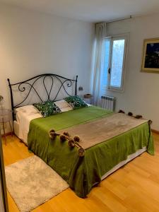 a bedroom with a large bed with a green blanket at REGINA - ROMANTIC STUDIO near RIALTO in Venice