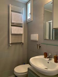a bathroom with a sink and a toilet and a mirror at REGINA - A cosy air conditioned studio just minutes from Rialto in Venice +12 photos