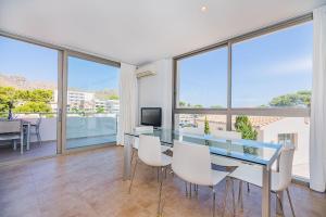 una sala da pranzo con tavolo in vetro e sedie bianche di MOLINS 3 a Cala Sant Vicenç