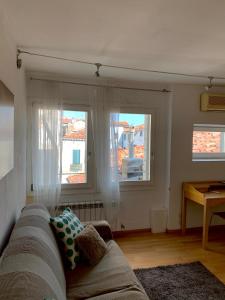 a living room with a couch and two windows at REGINA - ROMANTIC STUDIO near RIALTO in Venice