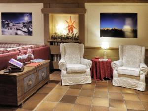 salon z 2 krzesłami i stołem w obiekcie Hotel Bertelli w Madonna di Campiglio