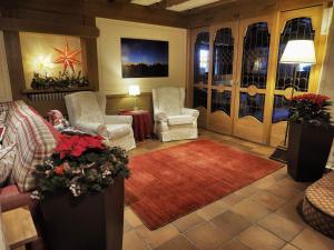 a living room with two chairs and a red rug at Hotel Bertelli in Madonna di Campiglio