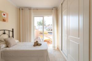 ein Schlafzimmer mit einem Bett, auf dem ein Teddybär liegt in der Unterkunft Apartamento Ibn Sadi8 in Nerja
