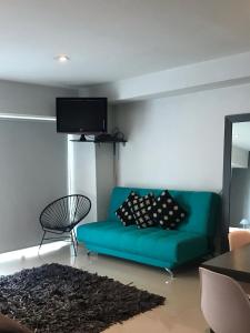 a living room with a blue couch and a tv at Studio Loft Polanco with POOL in Mexico City