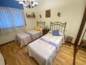 バイヨーナにあるPiso Céntrico Baionaのベッドルーム1室(ベッド2台、シャンデリア付)