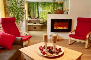 a living room with red chairs and a fireplace at Urlaub in Crottendorf für bis zu 8 Personen in Crottendorf