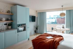 1 dormitorio con 1 cama y cocina con ventana en Bermonds Locke, en Londres