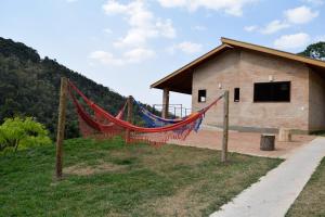 a building with a hammock in front of it at Chalés Boa Vista in Gonçalves