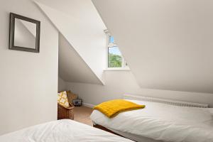 a attic bedroom with two beds and a window at Chambers Place in Reading