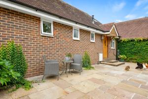 una casa de ladrillo con mesa, sillas y un perro en Chambers Place, en Reading