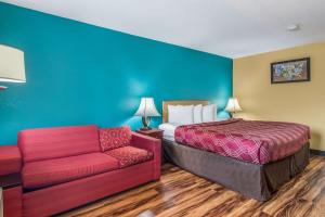 a hotel room with a bed and a couch at Econo Lodge Hotel Bradford in Bradford