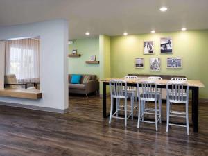a waiting room with a table and chairs at WoodSpring Suites Albuquerque in Albuquerque