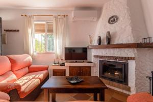 sala de estar con sofá y chimenea en Cortijo Encarni, en Frigiliana