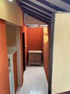 um corredor com paredes cor de laranja e uma mesa num quarto em Villa Anjing 2 em Nusa Dua