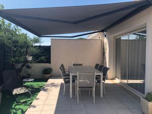 a patio with a table and chairs under a canopy at Maison individuelle à 10 mn à pied du centre ville in Uzès