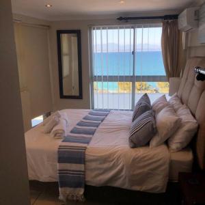 Schlafzimmer mit einem großen Bett und Meerblick in der Unterkunft Nautica 501 in Mossel Bay