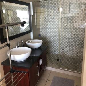 a bathroom with two sinks and a glass shower at Nautica 501 in Mossel Bay
