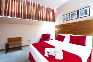 um quarto com uma cama grande e um cobertor vermelho em Hospedium Hotel Casino Del Tormes em Salamanca