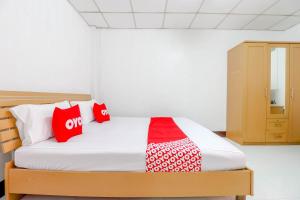 um quarto com uma cama com almofadas vermelhas e brancas em OYO 525 MRT Phetkasem 48-1 Place em Bangkok