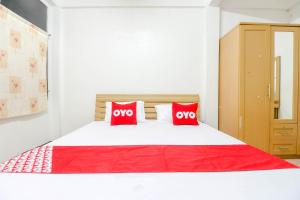 a bedroom with a large white bed with red pillows at OYO 525 MRT Phetkasem 48-1 Place in Bangkok