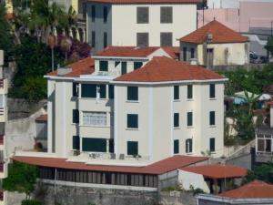 un edificio blanco con techo rojo en Residencial Do Vale, en Funchal