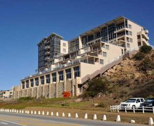 a large building on top of a hill next to a road at Nautica 501 in Mossel Bay