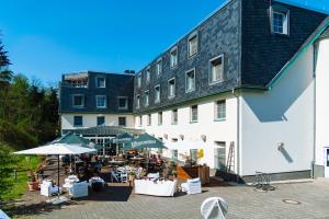 a building with tables and umbrellas in front of it at Landhotel Potsdam in Potsdam