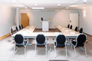 a large conference room with a long table and chairs at Landhotel Potsdam in Potsdam