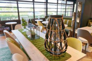 a vase sitting on top of a table with chairs at Kyriad Crepy En Valois in Crépy-en-Valois