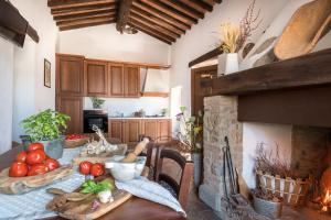 a kitchen with a table with vegetables and a fireplace at Casa Dovi in Rosennano