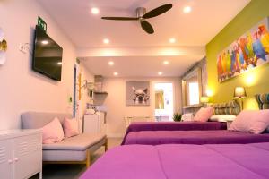 uma sala de estar com camas roxas e uma ventoinha de tecto em Chueca - Room Apartments em Madri
